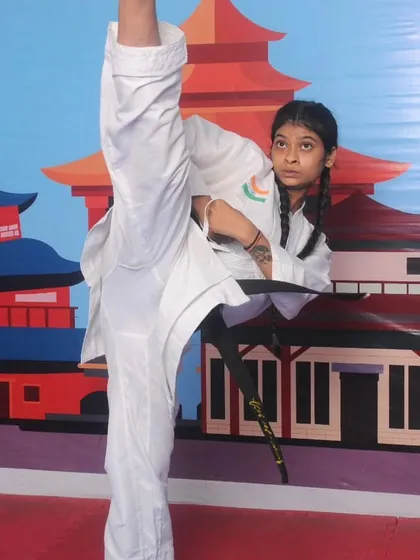 We train our students to achieve peak physical performance. This black belt student demonstrates exceptional flexibility and control with a perfect high kick, a result of dedicated practice and expert coaching.
