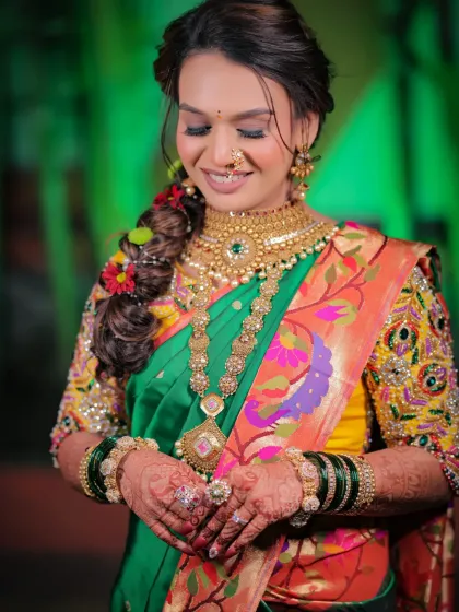 A beautiful candid moment of the bride looking down at her hands, showcasing the rich colors of her attire and the intricate henna art.