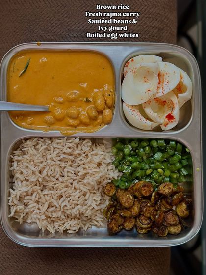 This eggetarian plate features brown rice, fresh rajma curry, sautéed beans and ivy gourd, and boiled egg whites.