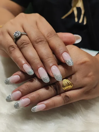 A different perspective of the silver glitter French tips, showing how they catch the light and add a glamorous touch.