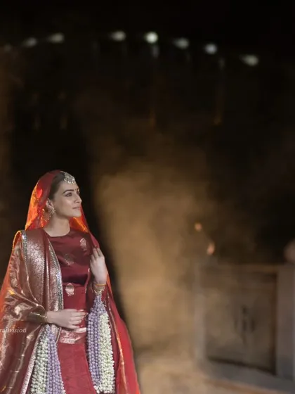 A dreamy, atmospheric shot of Kriti Sanon with smoke and fireworks. This frame feels magical and highlights the spectacular setting of the fashion show.