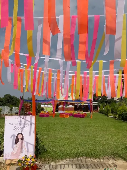 A colorful Mehendi entrance created with hanging ribbons in neon and pastel shades, a simple yet highly effective decor idea.