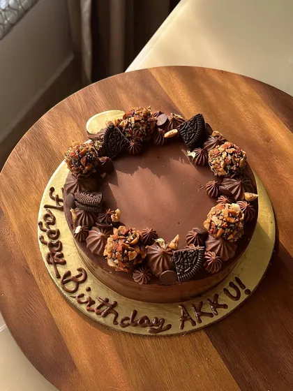 Our Majestic Chocolate Truffle cake. This creation features a 54% dark chocolate cake with hints of coffee, crowned with hand-rolled roasted almond truffles and Oreo pieces.