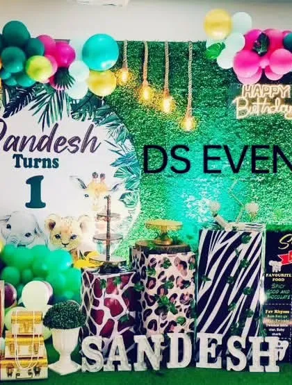 I bring the wild to the party with my popular Jungle Safari theme. This setup includes a lush greenery backdrop, a custom circular name board, animal print plinths for the cake, and a vibrant balloon arch with animal-themed accents.