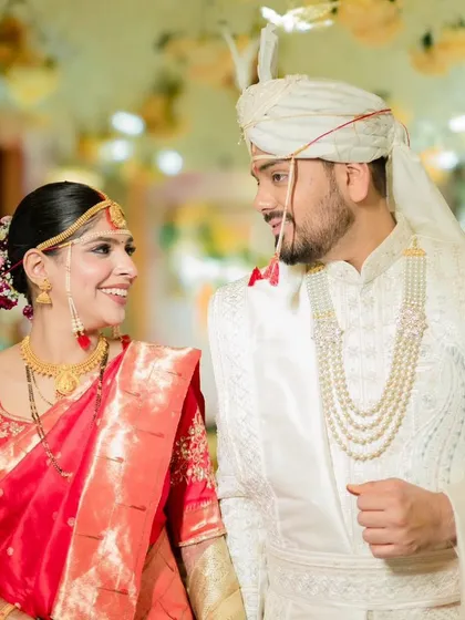 A candid moment between the happy couple. Her makeup looks just as stunning in these unposed shots, highlighting the importance of a flawless, long-lasting application.