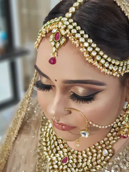 I call this my 'golden goddess' look. The focus is on a shimmering golden cut crease eye makeup, voluminous lashes, and a warm, glowing complexion. This style is perfect for brides who want a glamorous yet traditional feel.