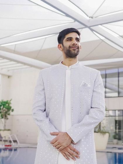 Another angle of the groom by the pool, capturing his relaxed yet elegant look for the engagement festivities.