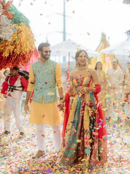 The couple walks hand-in-hand through a shower of colorful confetti, a moment of pure magic.