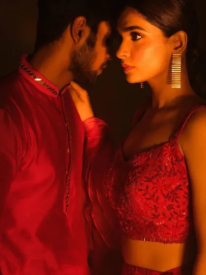 A romantic close-up of a couple, bathed in warm, dramatic light. The bride's makeup is luminous and her eyes are softly defined, creating an intense and passionate look perfect for a pre-wedding photoshoot.