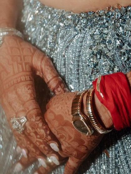 A detail shot of Nikita's sangeet look, showing the intricate silver beadwork on her lehenga and her diamond-studded bracelets.