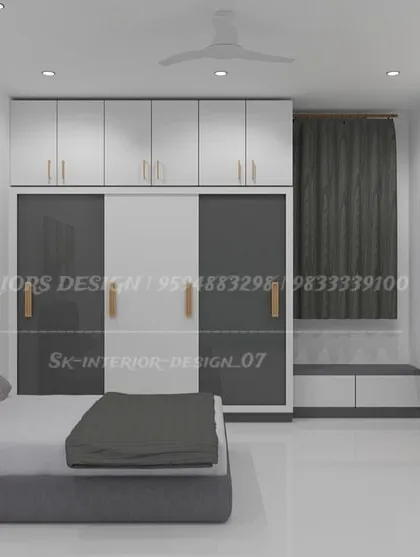 This bedroom combines a dual-tone sliding wardrobe with a compact TV unit. The design is clean and functional, with loft storage for seasonal items.