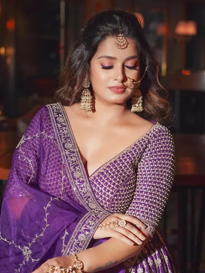 A three-quarter view of this beautiful reception look. The soft waves in her hair and the glowing makeup create a dreamy effect.