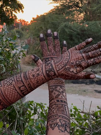 A close-up of the bridal mehendi against a natural green background, making the henna design pop.