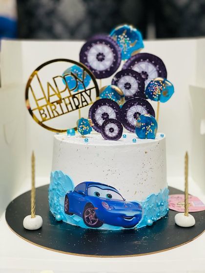 A sleek car-themed cake for a car lover, featuring a blue sports car.