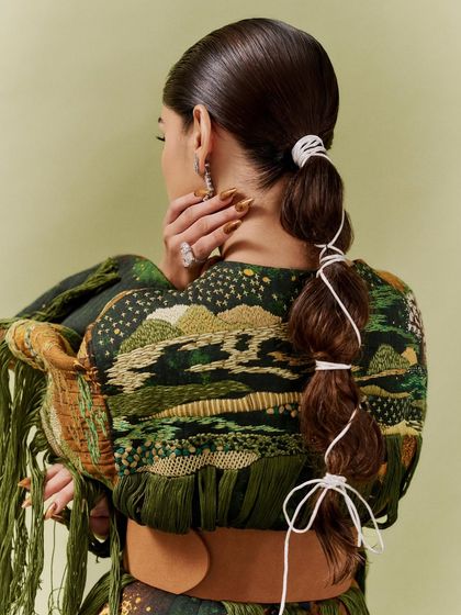 This view shows how the nails tie into the entire aesthetic of the photoshoot, from the intricate hairstyle to the detailed embroidery on the jacket. Every detail matters.