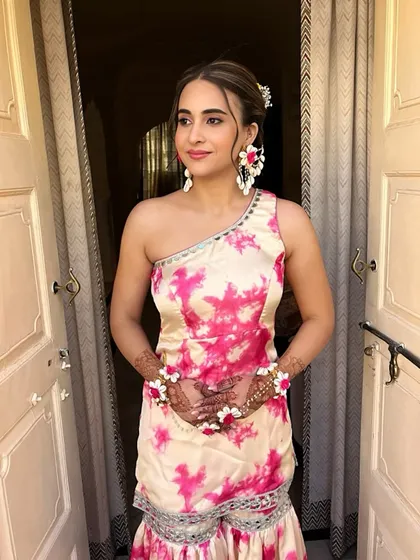 The client looks beautiful and happy with her unique floral braid. This hairstyle is a perfect blend of traditional and bohemian styles.
