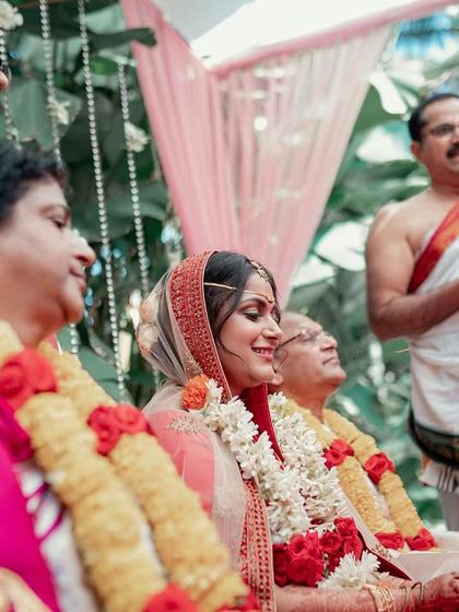 A bride sits with her family during the wedding ceremony, their expressions full of joy and pride. These candid family group shots are treasured memories.