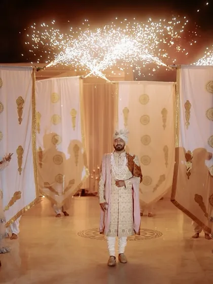 A royal groom's entry, complete with dancers holding banners and cold pyros lining the aisle. This is how you make a statement.