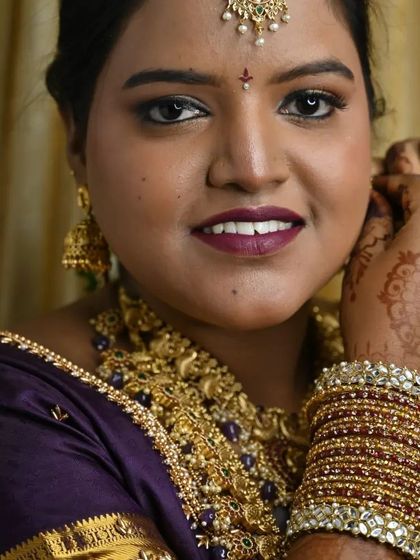 The final touches. This candid shot of the bride putting on her bangles shows the complete look, including the rich henna and perfectly coordinated jewellery.