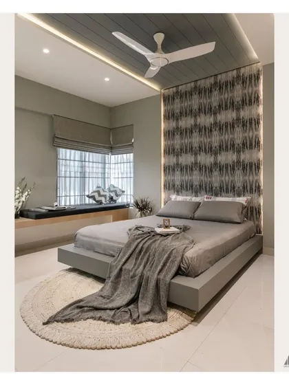 This bedroom was conceived as a tranquil sanctuary. It features a custom floating bed, a serene grey color palette, and a cozy bay window seat, all working together to create a sophisticated and restful personal space.