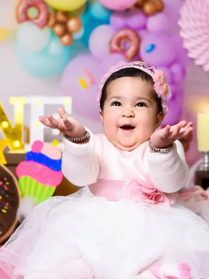 All dressed up and ready for her first birthday portrait. This was taken just before the cake smash, capturing her sweet expression in a beautiful pink and white dress.