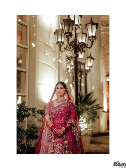 A classic bridal portrait taken at night, with the bride standing under elegant street lamps that create a beautiful bokeh effect.