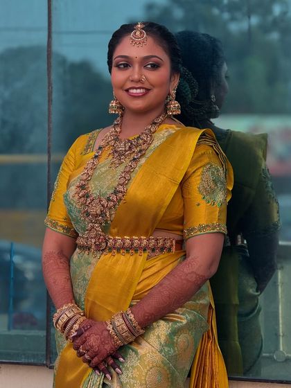 A beautiful portrait of Prithivi against a reflective surface. Her makeup is perfectly balanced, with defined eyes and a lip colour that complements her saree.