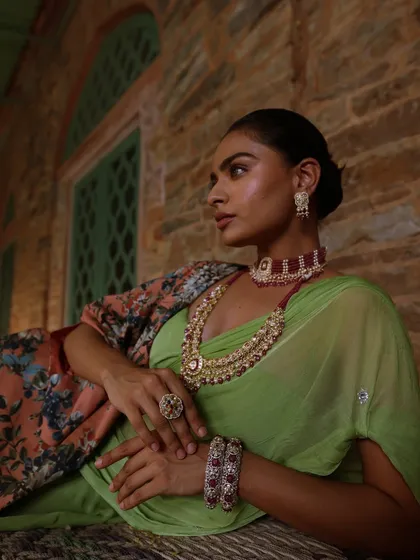 This look is all about making the jewellery the hero. I paired a simple green chiffon saree with a stunning layered ruby and polki necklace set, creating a look of regal elegance.