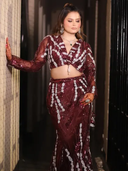 Another pose in the maroon drape saree, showing how it drapes around the body.