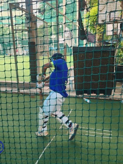 A young player executes a perfect shot during a net session. We focus on teaching proper technique from a young age to ensure our players build a solid foundation for their batting skills.