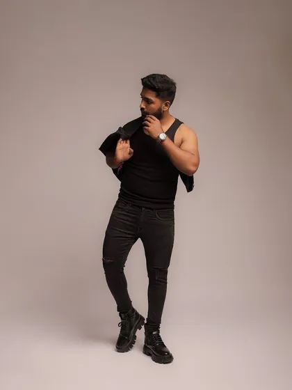 A classic fashion pose, with the jacket slung over the shoulder, conveying a cool and relaxed attitude.