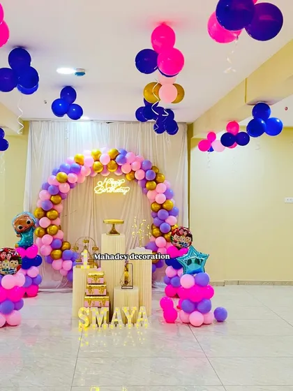 A Frozen-inspired color theme with a balloon arch in gold, pink, and purple. The setup includes character foil balloons and balloons floating on the ceiling.