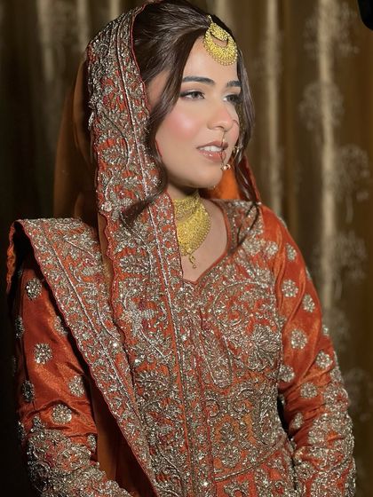 The side profile of this beautiful Muslim bride shows off her soft hairstyle and the way the light catches her glowing skin. It's a look of pure grace.