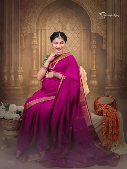 We celebrate tradition with our fine-art studio sessions. This portrait features a mother-to-be in a gorgeous magenta silk saree, seated gracefully against a regal, palace-themed backdrop, creating a timeless and culturally rich image.