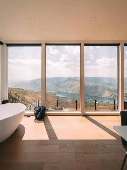 A bathroom with a view. This image showcases a freestanding tub positioned to take full advantage of the stunning natural scenery, a signature feature of our luxury prefab homes.