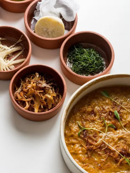 Our Jackfruit Haleem, slow-cooked for 12 hours, is served with traditional garnishes like fried onions and fresh herbs. A vegetarian highlight from our Holiday Feast.