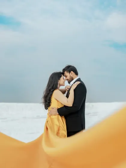 A close-up of a romantic moment from a pre-wedding shoot. The flowing fabric of our yellow trail gown adds a beautiful foreground element, creating a soft and intimate photo.