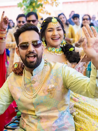 A fun moment with the bride and groom during the Haldi festivities. Her makeup is waterproof and smudge-proof, ready for all the fun and games.