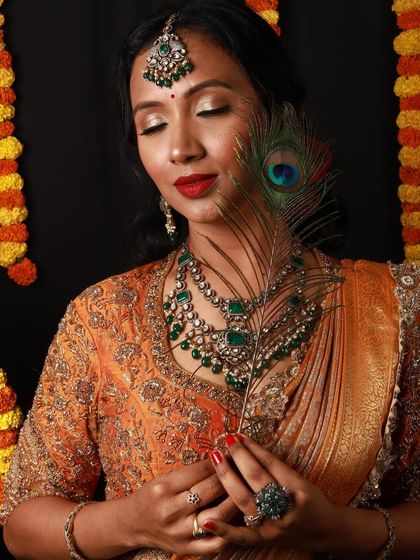 A festive and regal makeover perfect for celebrations like Diwali. This look features warm, shimmering eyes, a classic red lip, and beautiful emerald jewelry to complete the traditional yet glamorous style.