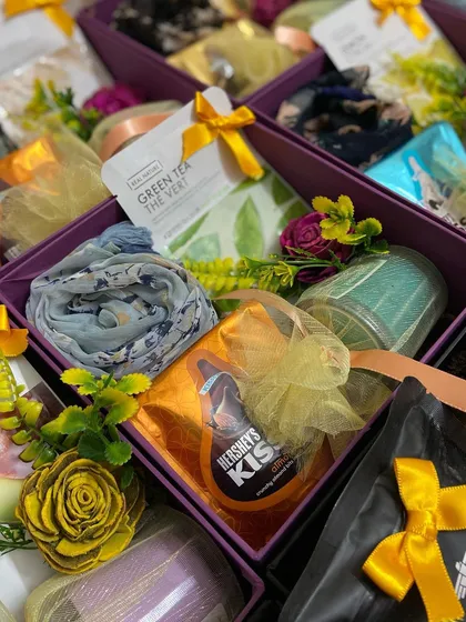 A closer look at the individual wedding favor boxes for female guests. Each box contains a beautiful scarf, Hershey's Kisses, a green tea bag, and other small, thoughtful items.