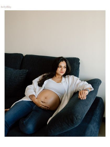 Lost in thought, dreaming of the future. A candid moment from a cozy in-home session, capturing the contemplative side of pregnancy.