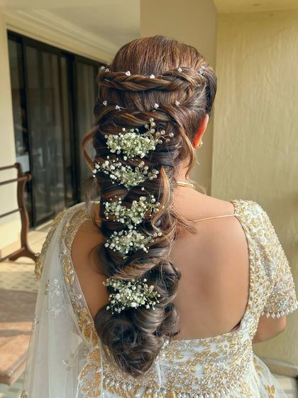 A full view of the textured pull-through braid with baby's breath, a romantic and detailed hairstyle.