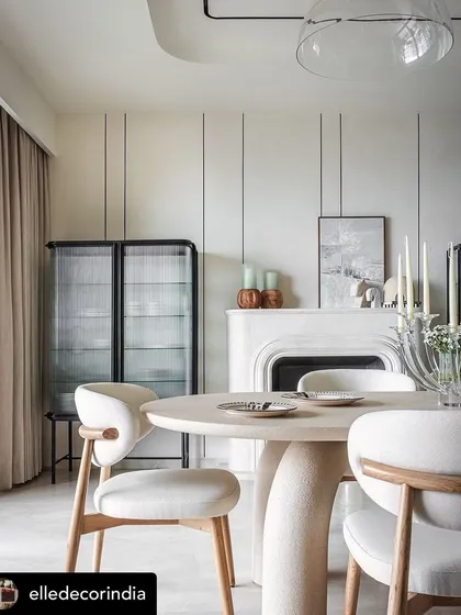 A serene and elegant dining space featured in Elle Decor, showcasing our work. The sculptural dining table and minimalist chairs with wood frames and upholstered seats create a sophisticated, light-filled atmosphere.