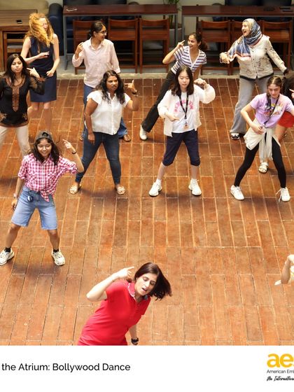 Participants strike a pose during the 'Arts in the Atrium' Bollywood dance session. The event is filled with energy, laughter, and a shared sense of community spirit.