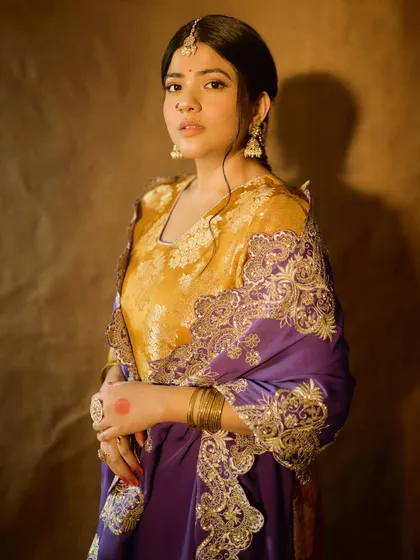 A regal portrait of Sakshi Gopal. The makeup is rich and traditional, with a focus on the eyes and classic jewellery like a maang tikka and nose ring.