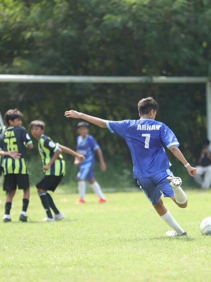 Our number 7, Arnav, lining up a shot on goal, showcasing the "Bend it like Beckham" technique we practice.