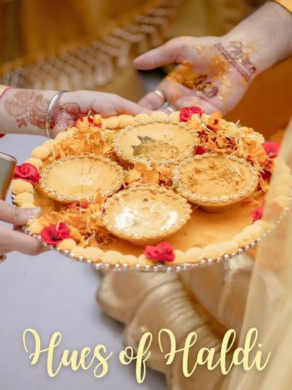 A close-up shot of the Haldi thali, beautifully arranged with turmeric paste and marigold flowers, ready for the ceremony.