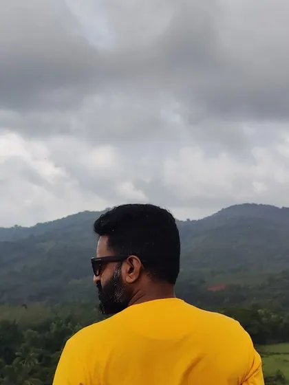 A trekker enjoying the view of the hills from a viewpoint.