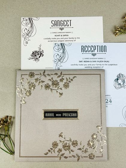 A beautiful suite featuring soft pastel paper with intricate gold foil floral vines. The matching inserts for the Sangeet and Reception continue the theme with elegant swirls and motifs.