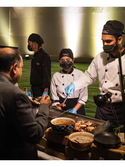 Our chefs serve a guest from a live grill, showcasing the seamless interaction and service flow at our events. We ensure every guest receives personal attention.